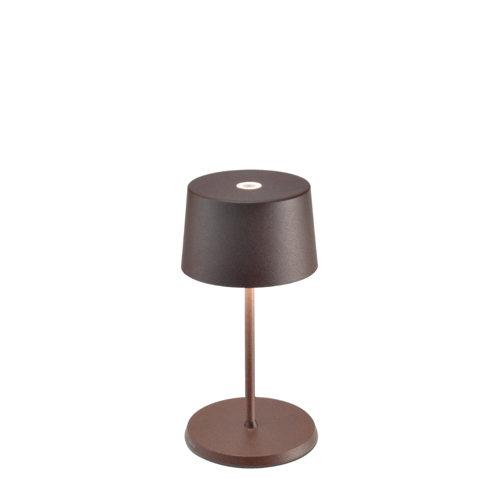 Lampe de table marron foncé avec abat-jour cylindrique, structure et base métalliques rondes, sur fond blanc.