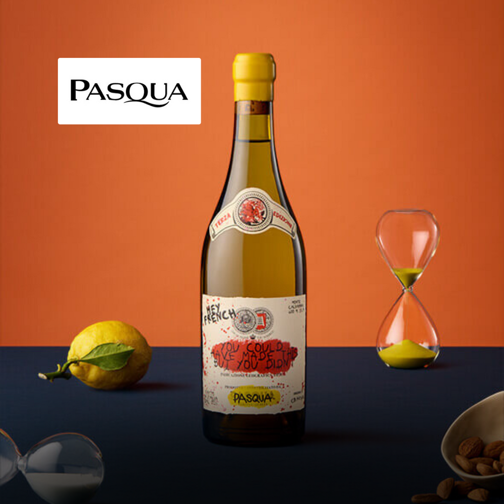 Bottiglia di vino bianco con etichetta decorata, limone giallo, due clessidre e mandorle su sfondo arancione