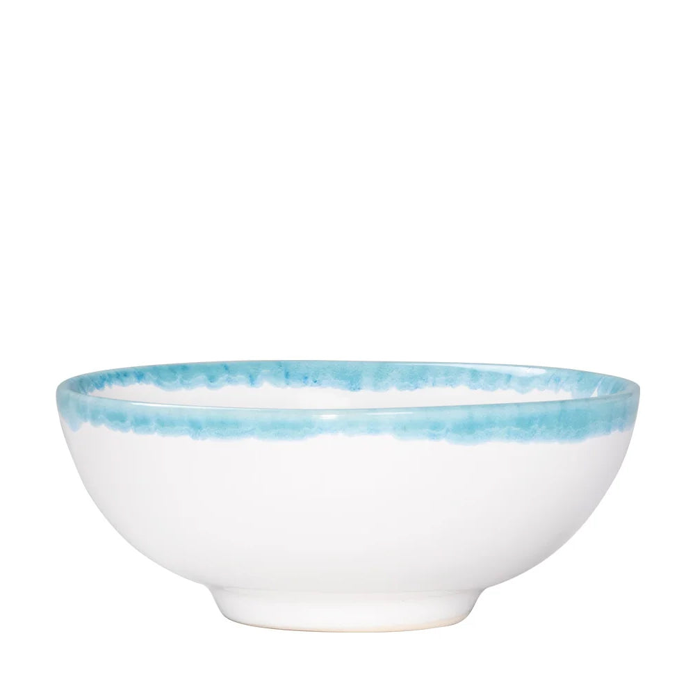 Ciotola bianca in ceramica con bordo blu, forma rotonda e superficie liscia.