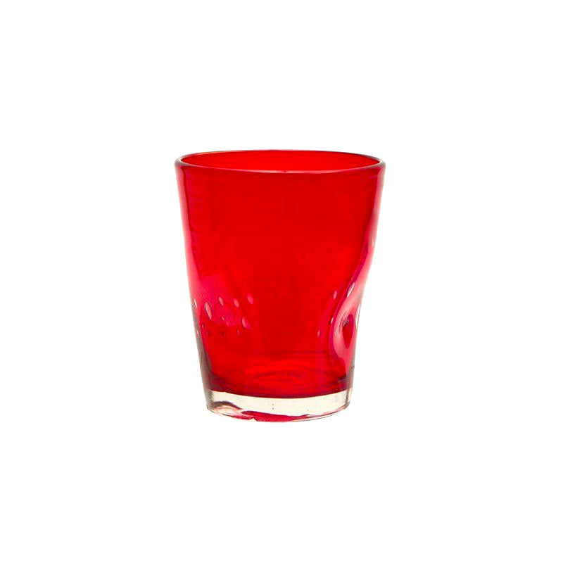 Bicchiere trasparente rosso in vetro con base chiara su sfondo bianco.