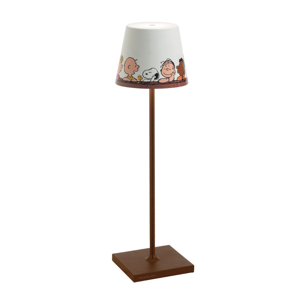 Tafellamp met bruine vierkante basis en witte kap versierd met Peanuts-personages in cartoonstijl.