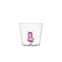 Transparent tumbler with a pink glass piglet inside, on white background.