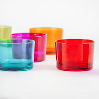 Cinque bicchieri di plastica colorati: azzurro, viola, rosa, arancione e rosso, disposti su fondo bianco.