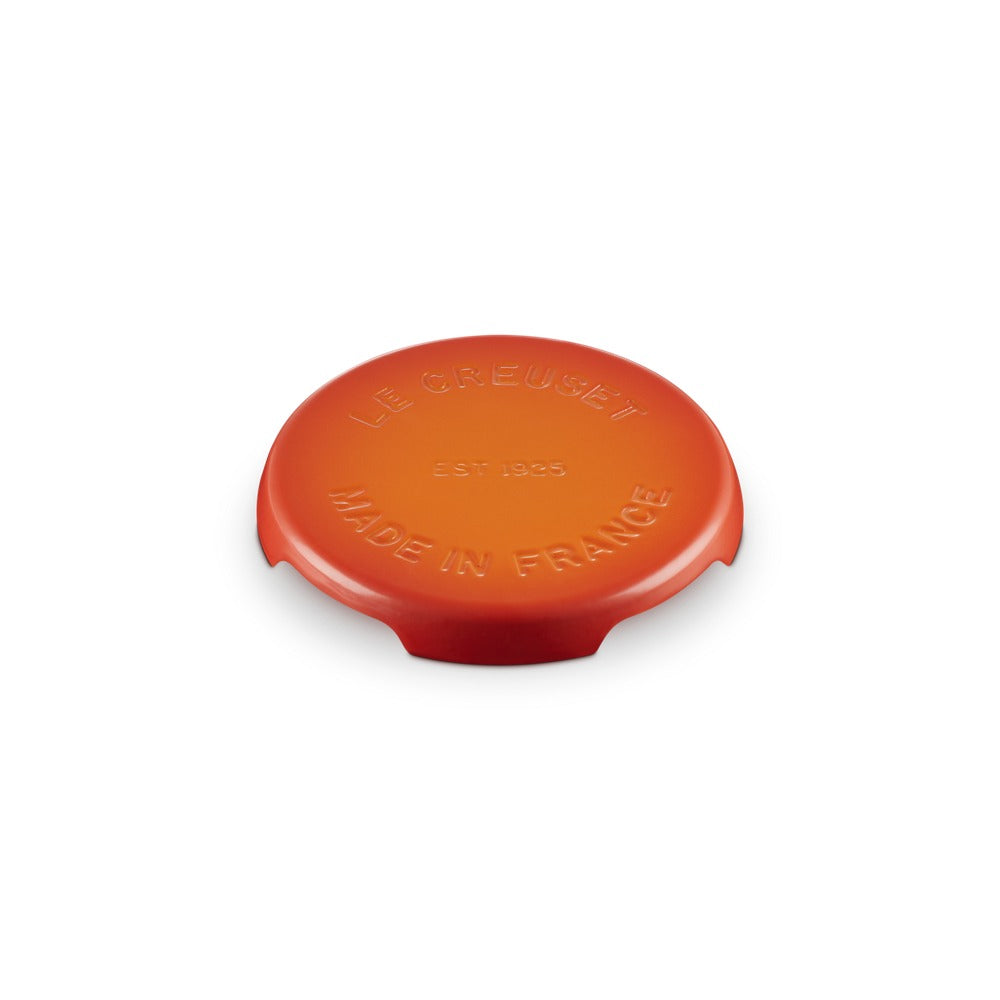 Coperchio di ceramica arancione brillante, rotondo, con scritte in rilievo: "LE CREUSET EST 1925 MADE IN FRANCE".