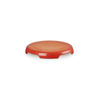 Coperchio circolare di colore rosso lucido con scritte dorate, in materiale ceramico, su sfondo bianco.