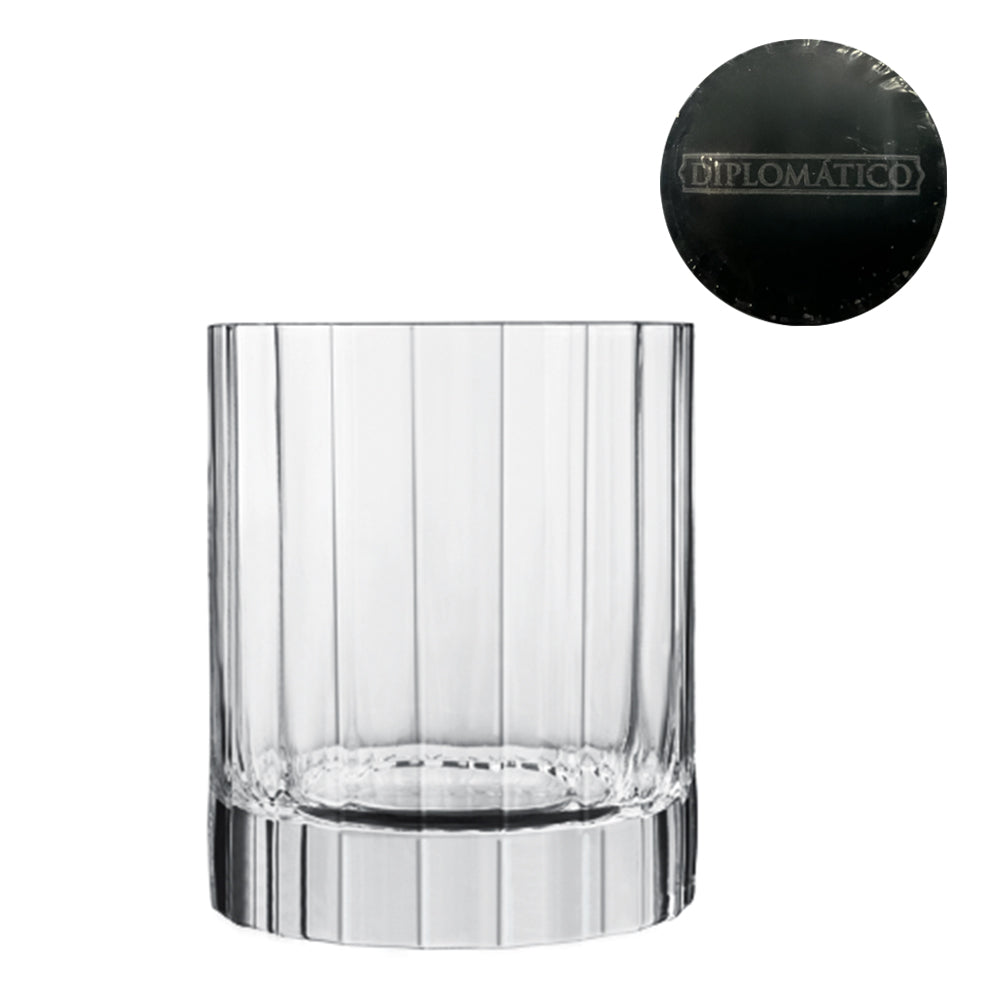 Transparentes Glas mit vertikalen Gravuren und dicker Basis, schwarze Verschlüsse mit Aufschrift Diplomático auf weißem Hintergrund