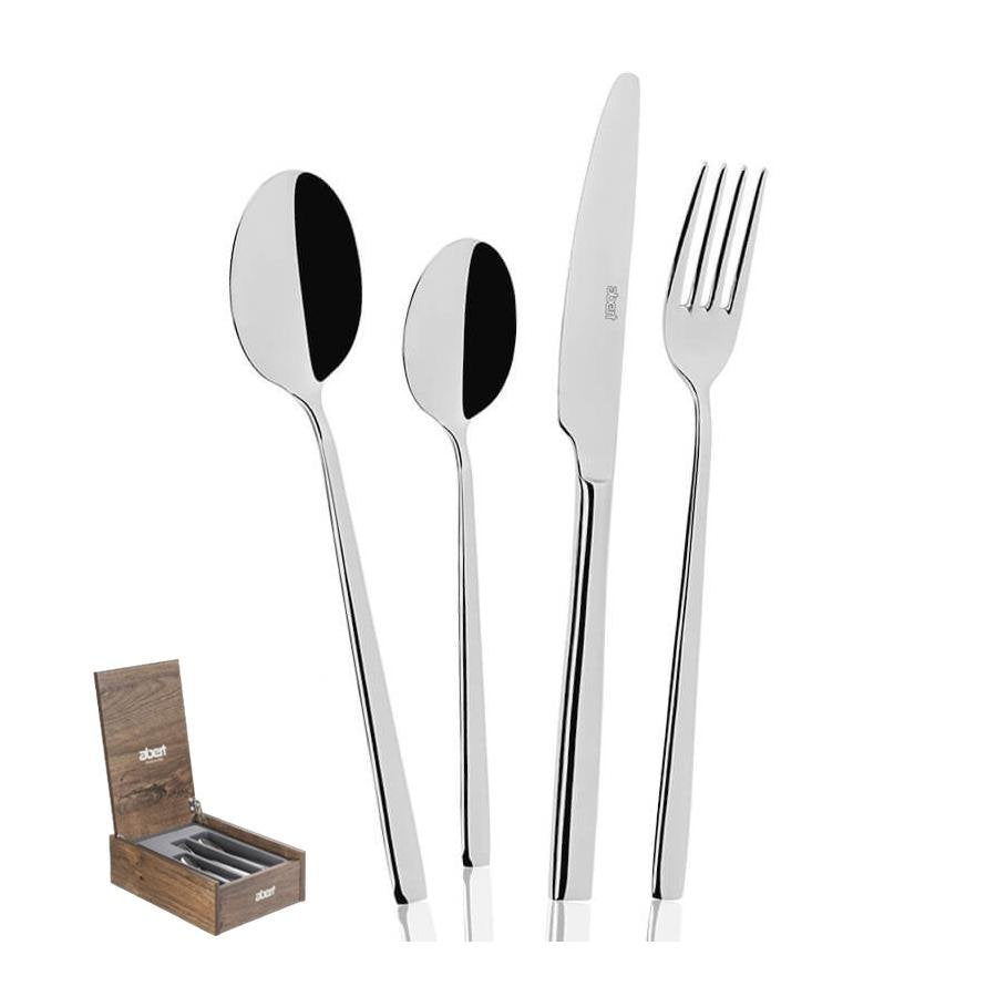 Set de cubiertos en acero inoxidable pulido, compuesto por cuchara, cucharilla, cuchillo y tenedor, presentado en una caja de madera.