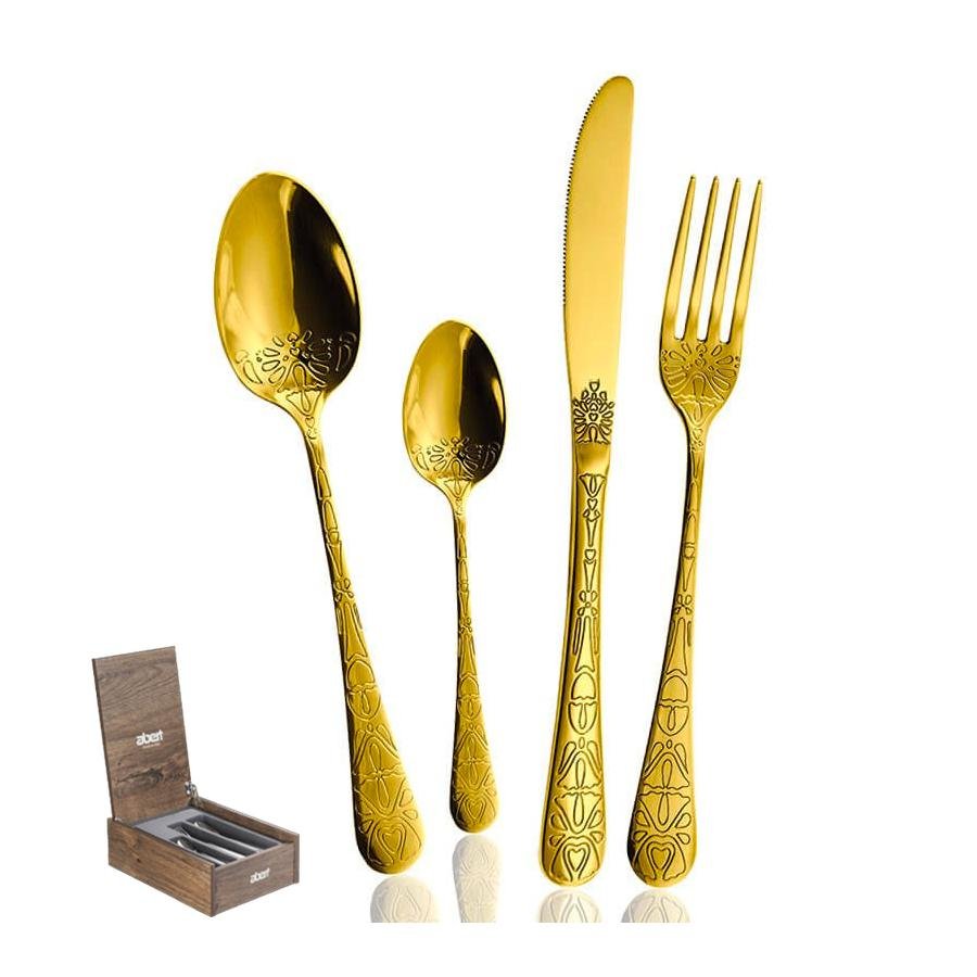 Set goldfarbenes Metallbesteck mit Dekorationen, bestehend aus Löffel, Teelöffel, Gabel und Messer, neben einer Box