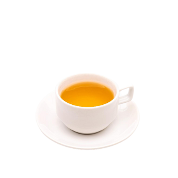 Tazza bianca in ceramica con bevanda calda gialla su piattino bianco, sfondo trasparente.