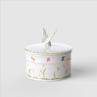 Boîte cylindrique blanche en céramique avec couvercle et décorations florales et papillons colorés. Papillon en relief sur le dessus.