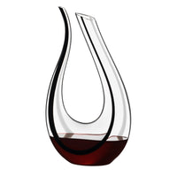 Deux carafes annulaires en verre avec vin rouge.