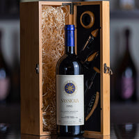 Botella de vino tinto Sassicaia 1995 en vidrio con tapón azul, en caja de madera con accesorios de vino y