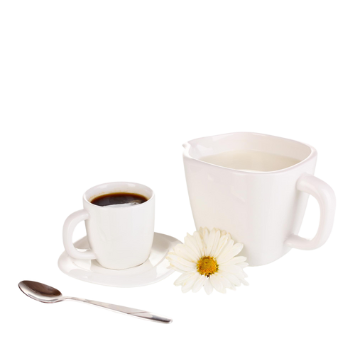 Tazza e piattino bianchi con caffè nero, zuccheriera bianca, cucchiaio e fiore bianco su sfondo chiaro.