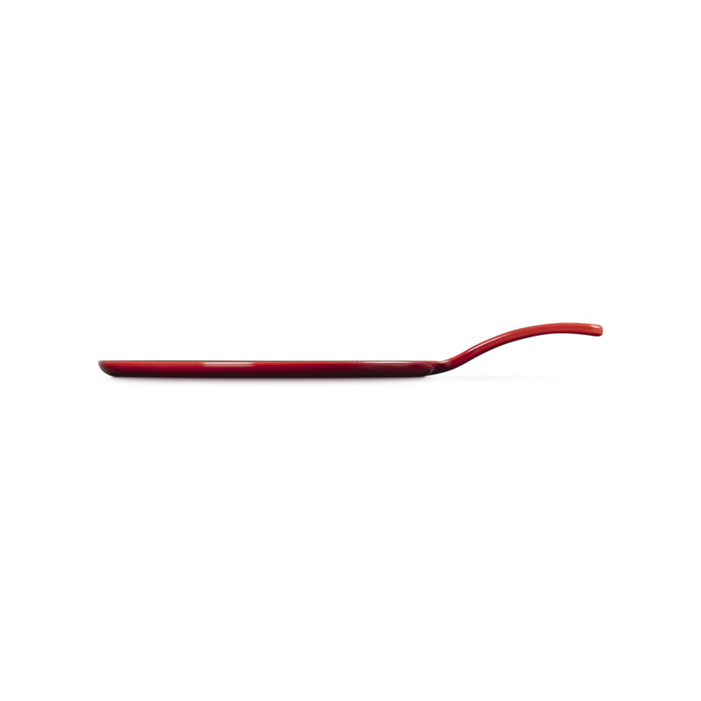 Teglia rossa lucida con manico curvo, di forma rettangolare e sottile, su sfondo bianco.