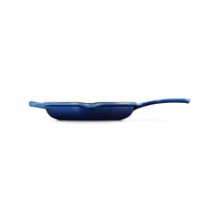 Poêle bleue de forme rectangulaire avec long manche, en fonte émaillée. Sur fond blanc.