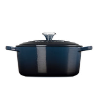 Pentola rettangolare in ghisa smaltata blu con coperchio nero e manici laterali, su sfondo bianco.