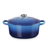 Casseruola ovale in ceramica blu con coperchio e manico. Finitura lucida e sfumature di blu, con un pomello argentato.