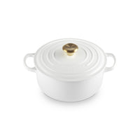 White cast iron saucepan with lid, golden handle and smooth surface. Simple and elegant decoration.