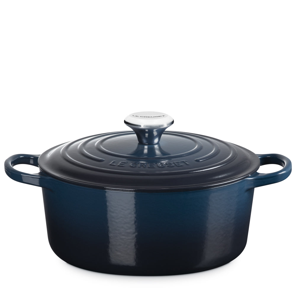 Oval enamelled cast iron casserole dark blue with lid and handle, featuring un elegant design and details refined.