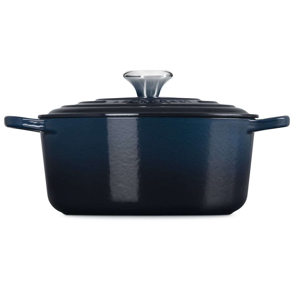 Dark blue rectangular enameled cast iron pot with black lid and steel handle, on white background
