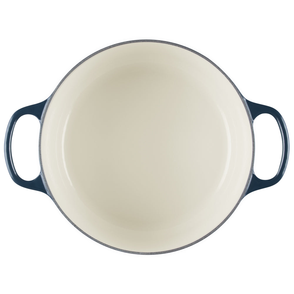 Round casserole enamelled white with side handles in dark blue, viewed from above on white background.