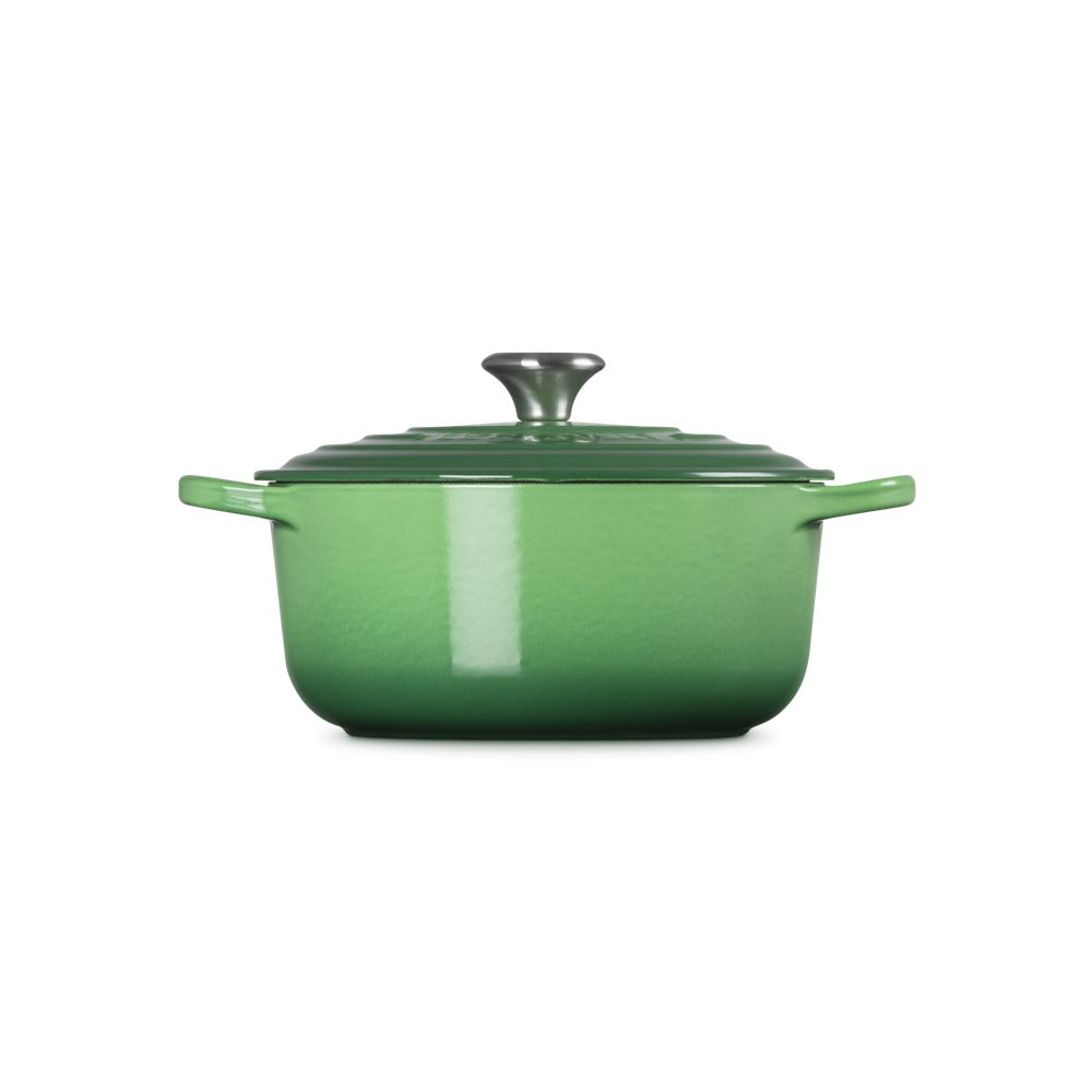 Bright green saucepan with lid, side handles and glossy surface, on white background.