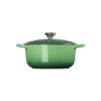 Bright green saucepan with lid, side handles and glossy surface, on white background.