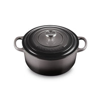 Round enamelled cast iron casserole, colour dark grey with matching lid and metal handle central.