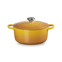 Round casserole of yellow colour with lid, side handles and knob in metal. surface enamelled and glossy.
