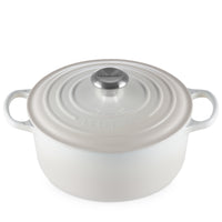 Witte ovale geëmailleerde gietijzeren pan met deksel, zijhandgrepen en metalen knop, merk Le Creuset zichtbaar op deksel.