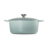 Geëmailleerde gietijzeren braadpan aquagroen met deksel en handgreep metalen, op neutrale achtergrond.