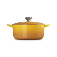 Yellow enamelled cast iron saucepan with lid and stainless steel handle, on white background.