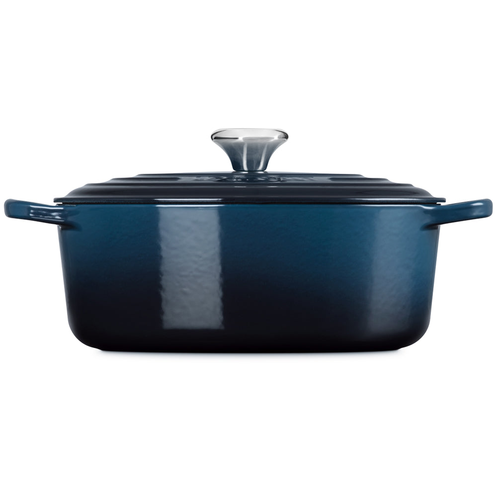 Cocotte carrée bleu foncé en fonte émaillée avec couvercle et poignée en métal brillant sur fond blanc