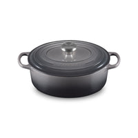 Cocotte en fonte émaillée grise, avec couvercle et poignée en acier, posée sur une surface claire.