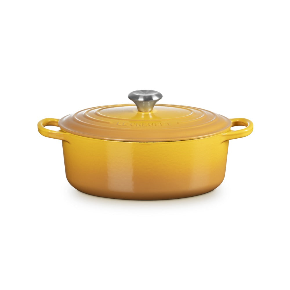 Cocotte ovale jaune avec couvercle et anses, en fonte émaillée, dotée d'un bouton en acier inoxydable.