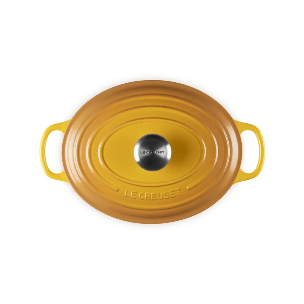 Couvercle ovale jaune en céramique avec poignée métallique centrale et anses latérales, design simple et élégant.