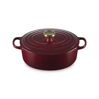 Casserole ronde en émail rouge avec anses et couvercle, dotée de bouton en or.
