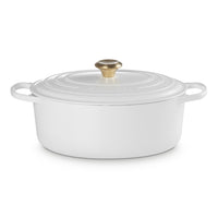 ovaal braadpan wit van gietijzer met gouden handgreep en deksel, glad en glanzend oppervlak, neutrale setting.