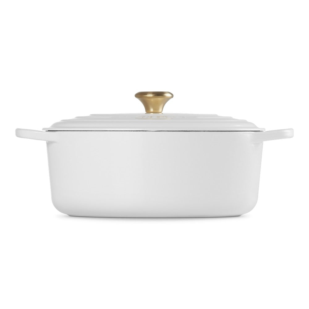 ovaal braadpan wit met deksel en gouden handgreep, glad en glanzend oppervlak, op neutrale achtergrond.