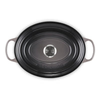 Zwart geëmailleerd ovaal gietijzeren bord met handgrepen, glad oppervlak en zilveren centrum, met gravure "LE CREUSET".