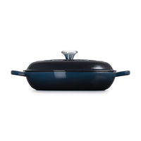 Casseruola rettangolare di colore blu scuro con coperchio trasparente e manici laterali.