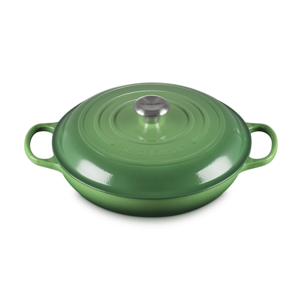 Casseruola di ghisa smaltata verde con coperchio e manici laterali, superficie lucida e dettagli in acciaio inox.