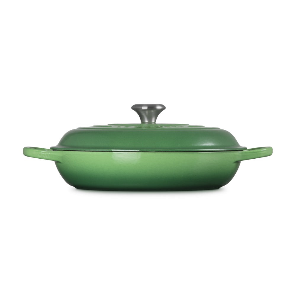 Casseruola di colore verde con coperchio grigio, manici laterali e superficie liscia, posizionata su sfondo bianco.