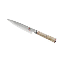 Coltello da cucina lama lunga in acciaio damascato con manico chiaro in legno e dettagli rossi.