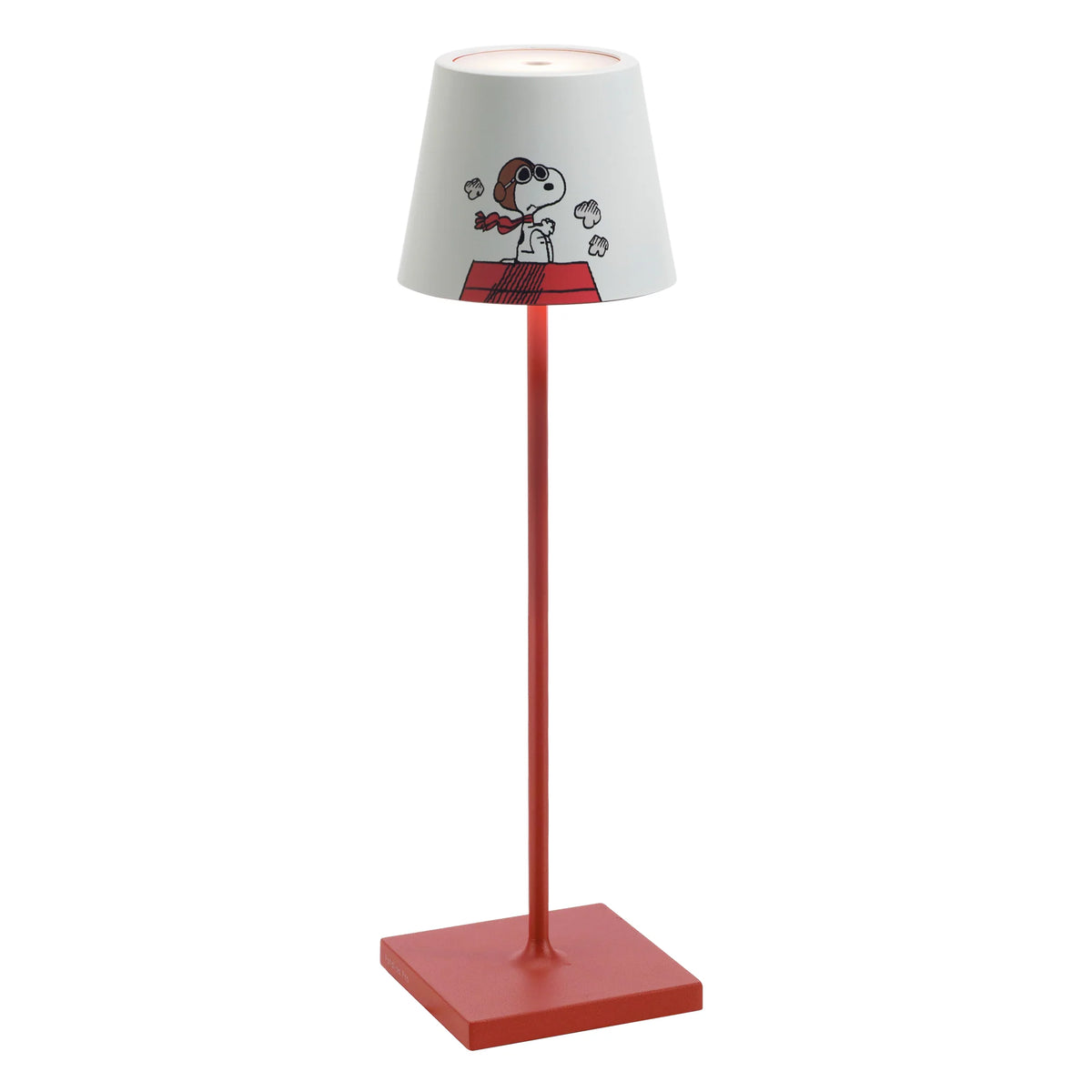 Lámpara de mesa con base y tallo rojos y pantalla blanca con dibujo de Snoopy con gafas y bufanda roja sobre caseta roja