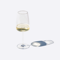 Bicchiere di vetro trasparente con vino bianco, forma conica e base piatta, ombra su sfondo chiaro.