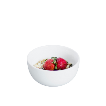Ciotola bianca rotonda contenente fragole rosse, fiocchi d'avena e semi vari.
