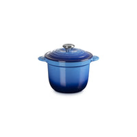 Casserole émaillée de bleu avec couvercle arrondeto et anses, en materiale ceramico, sur fond blanc.