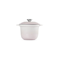 Casserole ronde avec base blanche et couvercle rosa, poignée en métal, sur fond blanc.