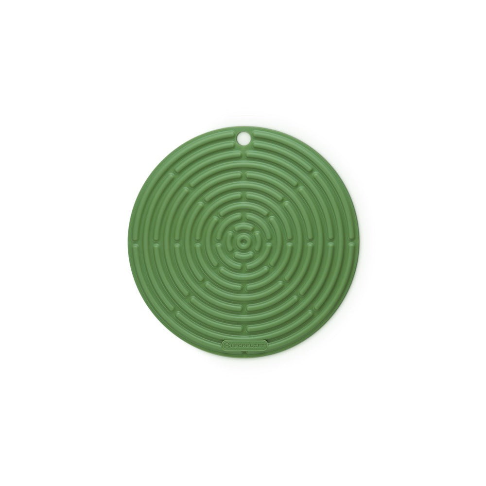 Tapis rond en silicone vert foncé à motifs spiralés, adapté pour protéger les surfaces des objets chauds.